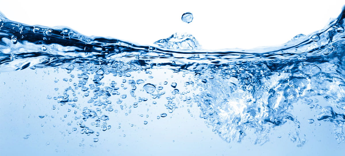 Wasser bewegt sich mit Luftblasen unter Wasser und Wassertropfen auf der Obefläche