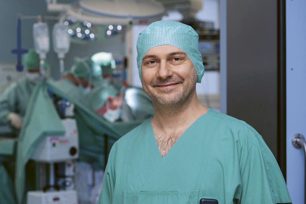 Portrait of Prof. Dr. med. Beat Müller in scrubs in the OR-room.